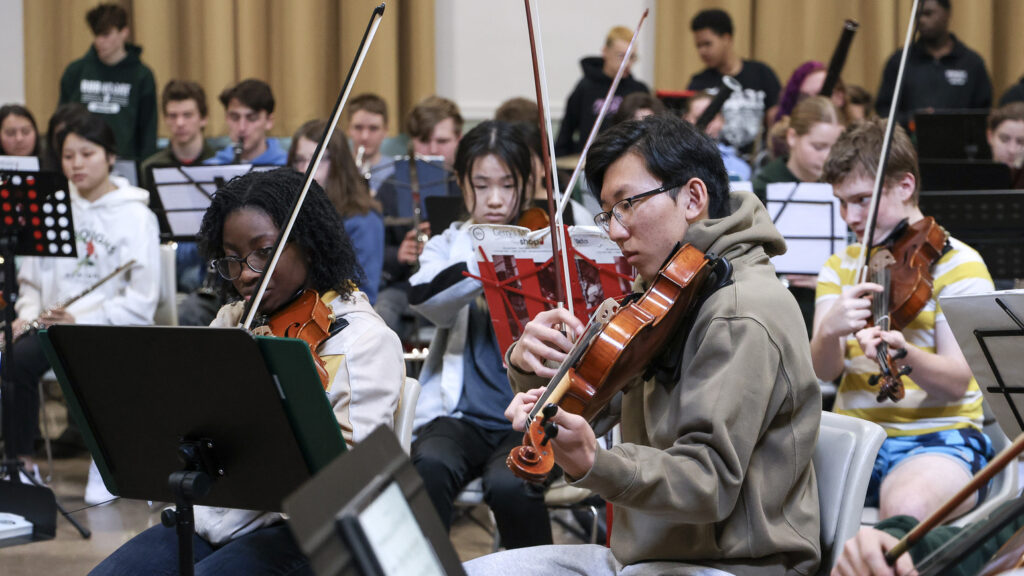 Members of the Worcester Youth Symphony Orchestra, Burncoat High School Orchestra and Shrewsbury High School Orchestra rehearse for their joint performance under the baton of guest conductor Dr. Mark Alpizar, music director of the Vermont Youth Orchestra Association, at Trinity Lutheran Church in Worcester, Mass. on Saturday, March 25, 2023. (Brita Meng Outzen)